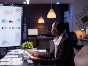 focused-workaholic-african-american-businesswoman-working-company-financial-charts-presentation
